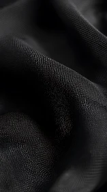 Textured fabric folds create geometric patterns in monochrome.