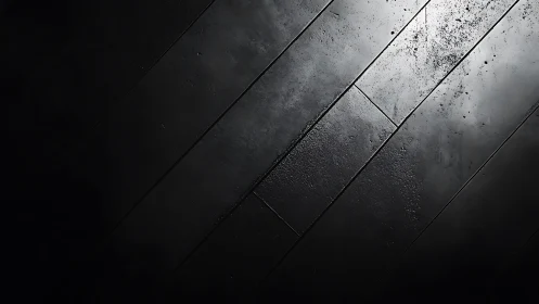 Oblique top view of wet textured black floor panels in shadow
