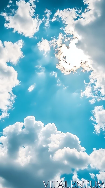 Sunlit cumulus clouds frame vivid turquoise midday sky.