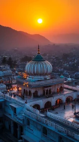 Sunset over domed Indian temple complex with glowing lanterns