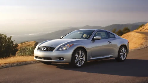Silver sports coupe shows aerodynamic bodywork on mountain road