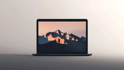 Laptop with mountain landscape wallpaper on neutral surface.