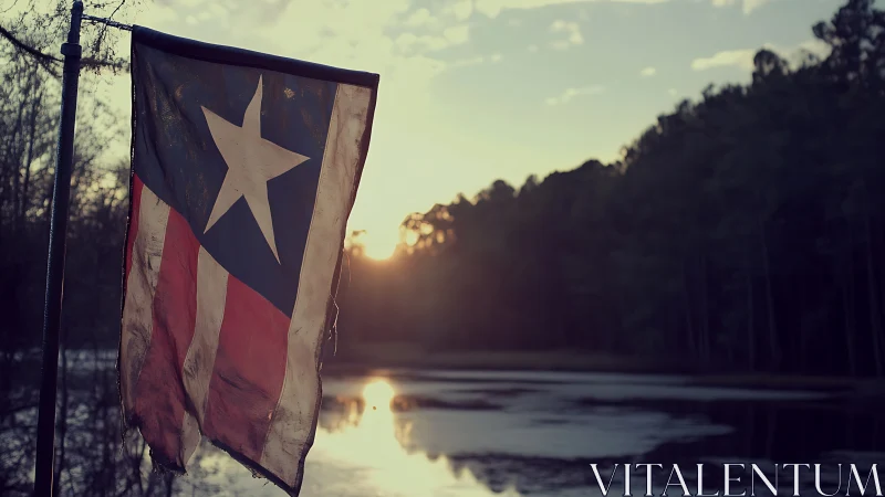 Weathered Lone Star flag at lakeside under soft sunset light.
