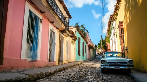 Cobbled urban street with pastel facades and parked sedan.
