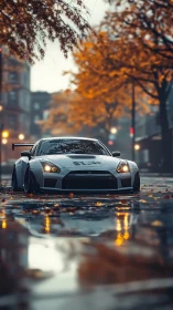 Widebody silver GT sports car on wet autumn city street.
