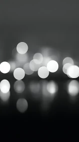 Soft monochrome bokeh lights drifting through quiet night.
