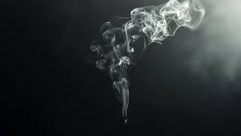 Rising cigarette smoke trail on dark black background.