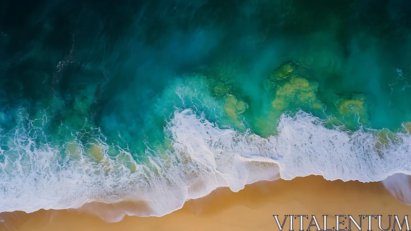 Overhead view of turquoise ocean surf on sandy shoreline.