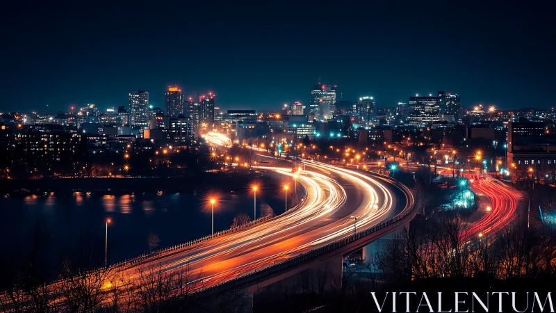 Urban night skyline with highway light trails and river.