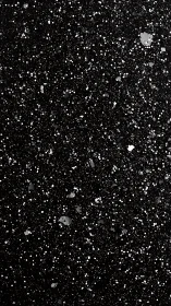 Black surface is covered with irregular white paint speckles