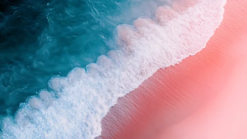 Aerial view of turquoise surf meeting smooth pink shore.