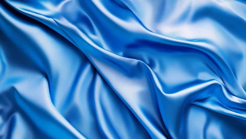 Satin blue fabric folds with high-gloss reflective highlights.