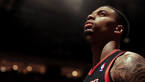 Focused basketball player gazes upward under arena lights
