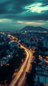 Long-exposure urban highway curves toward distant twilight mountains
