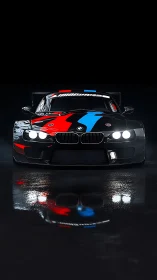 Front-facing BMW race coupe under high-contrast studio lighting.