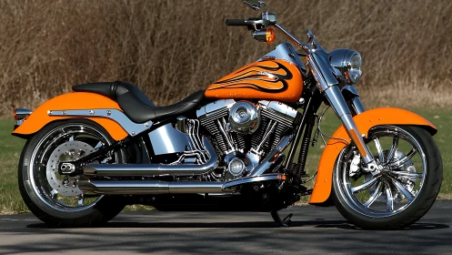 Orange custom cruiser motorcycle is parked on asphalt surface