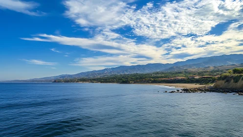 Coastal headland, ocean surface, and distant mountain range
