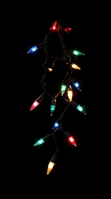 Strand of multicolored LED string lights hangs against black