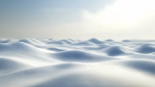 Soft snowy waves roll gently under a calm, hazy winter sky