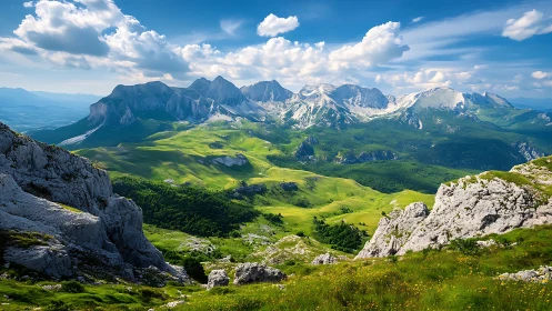 Mountain valley with rocky peaks under bright blue sky.