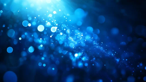 Abstract blue bokeh lights with glowing particles and soft blur.