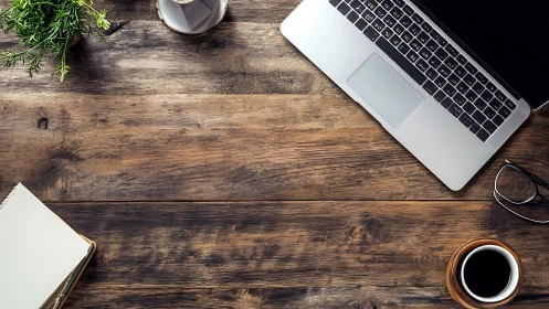 Overhead optical study of laptop workspace on rustic desk.
