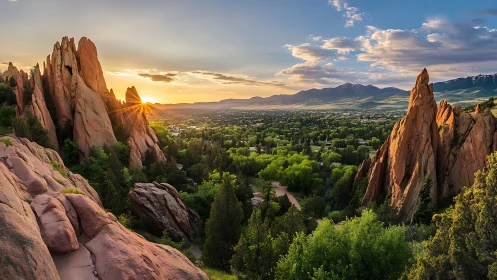 Sunlit red rock spires rise over a lush green valley at dusk