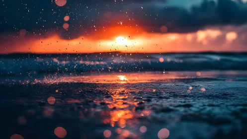 Sunset over wet shoreline with splashing water droplets.