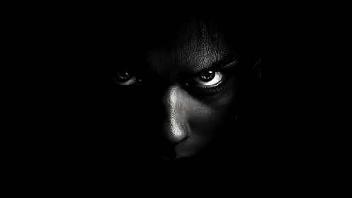 Low-key monochrome portrait isolating intense specular gaze.