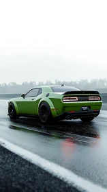 Green muscle car accelerates along wet racetrack at dawn