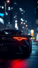 Sleek black sports car at night on wet city street.