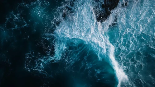 Turbulent teal surf collides with ink-dark open water.