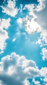 Sunlit cumulus clouds frame vivid turquoise midday sky.