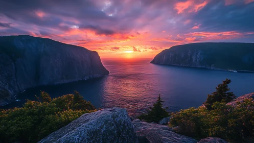 Fiery sunset gateway between brooding ocean cliffs.