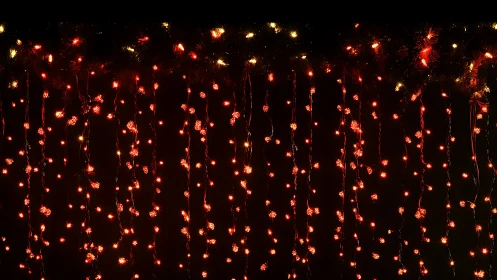 Cascading red fairy lights against deep festive darkness.