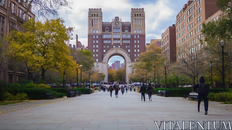 Autumn city walkway leading to arched university tower.