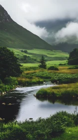 Mist-draped valley river curling through lush emerald hills.