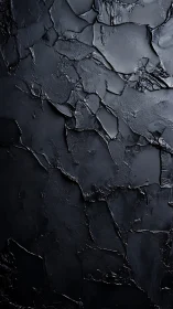 Textured black plaster surface with cracked abstract relief.