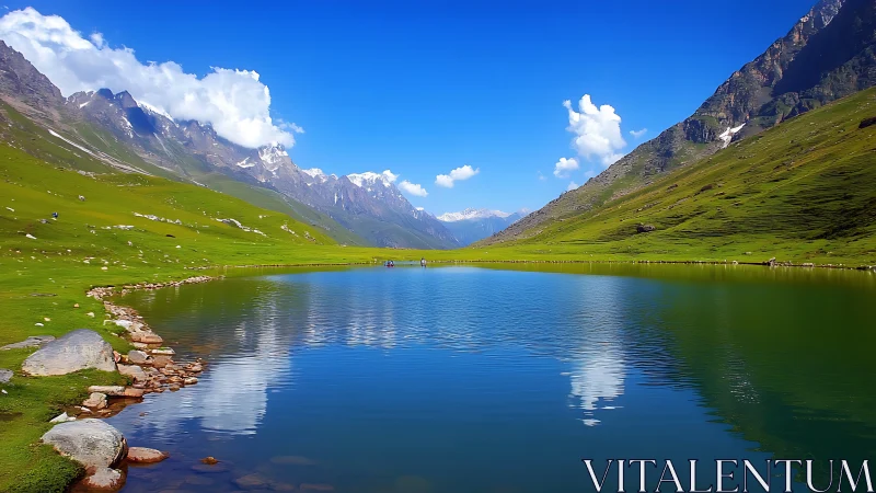 Mountain lake rests in vivid green valley beneath clear sky