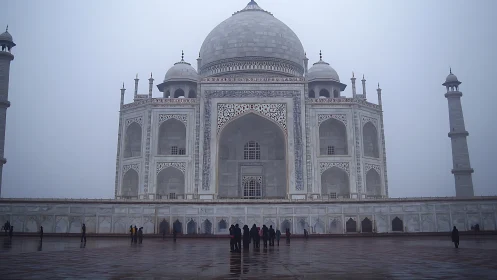 Fog-laden white marble mausoleum with domes and minarets.