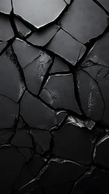 Glossy black cracked surface with sharp fractured plates.