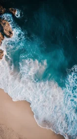 Aerial shoreline study contrasts cyan surf with sand
