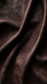 Folded brown leather surface reveals micrograin specular highlights