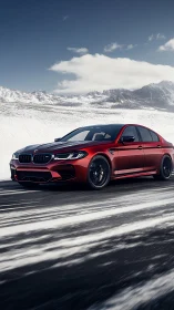 Red performance sedan driving on snowy mountain highway.