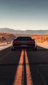 Black muscle car accelerates on empty desert highway