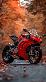 Red sport motorcycle on forest road with autumn foliage.