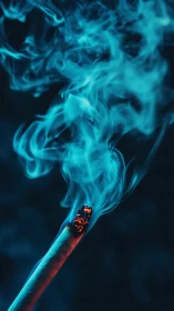 Glowing cigarette ember sends curling blue smoke upward