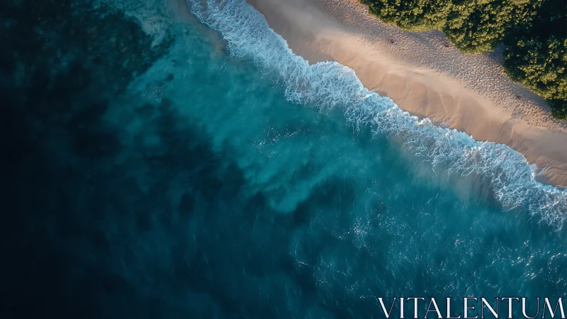 Aerial view of blue ocean waves meeting sandy shore.