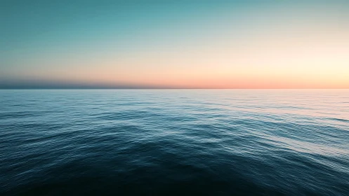 Calm ocean horizon glows beneath a pastel sunrise sky.