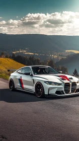 Track-tuned BMW coupe on sunlit mountain pass road.